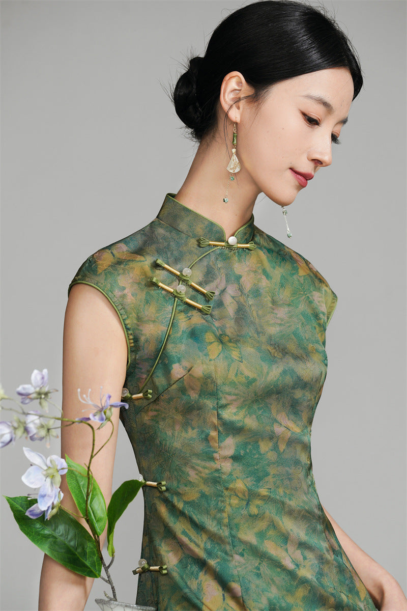 Langes grünes Qipao mit goldenem Blumen- und Schmetterlingsmuster