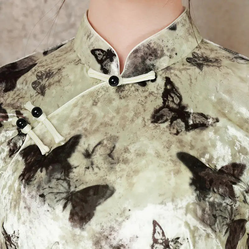 Traditional Chinese garment with butterfly patterns and black buttons.