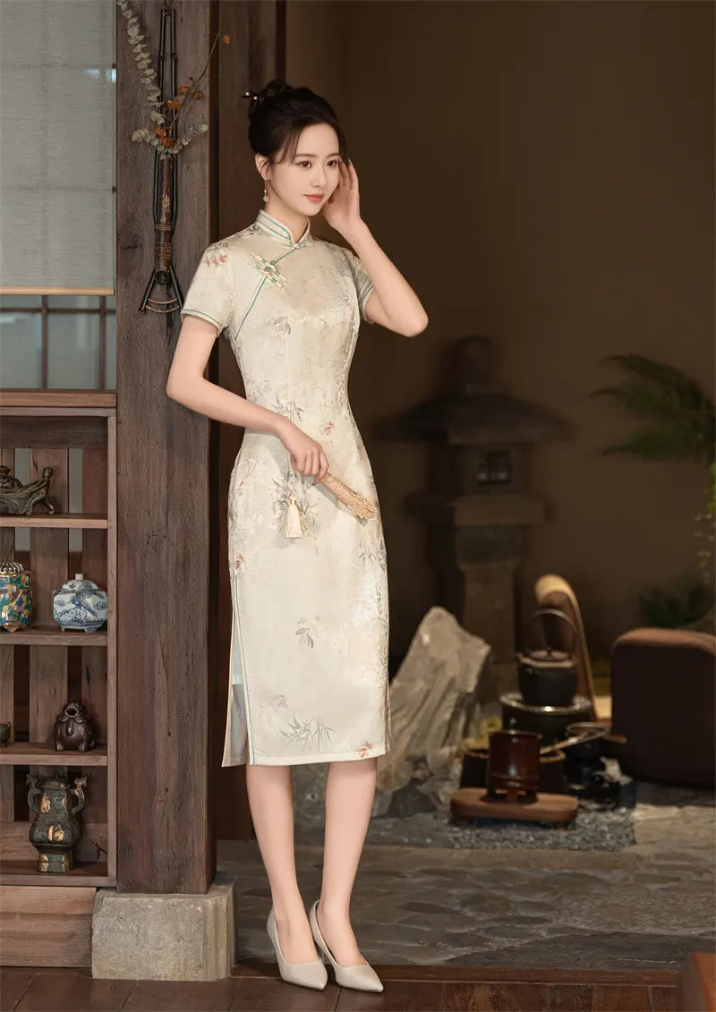 Woman in a traditional Beige Vintage Short Sleeve Midi Qipao Dressstanding in a room with wooden shelves and decorative items.