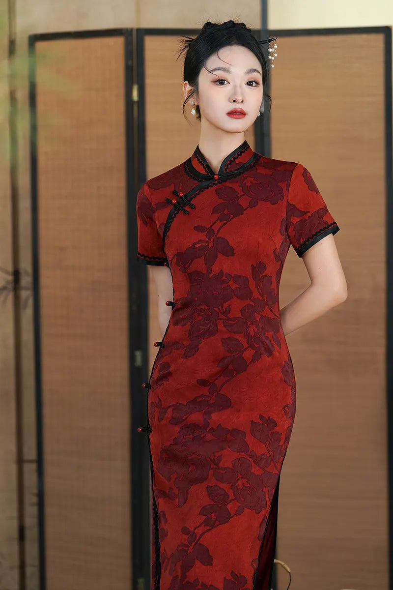 Woman wearing Deep Red Floral traditional chinese Qipao Cheongsam Dress with Black Trim with a blurred background