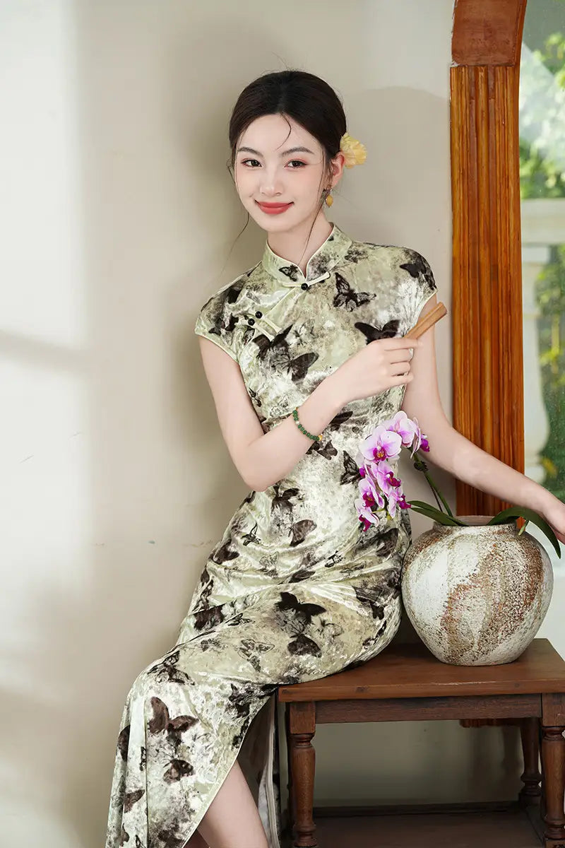 Woman in a green Elegant Velvet Qi pao Dress with Butterfly Print  holding a vase with flowers indoors