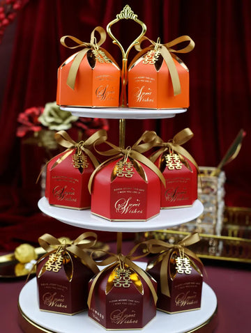 Three-tiered stand with red and gold Elegant chinese Wedding Favor Boxes with Double Happiness Charm labeled 'Wishes' against a red background