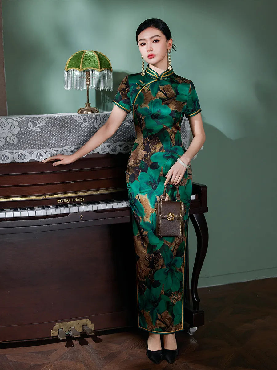 Woman in a Emerald Green Floral Silk Chinese Qipao Cheongsam Dress standing next to a piano in a room with a green wall.