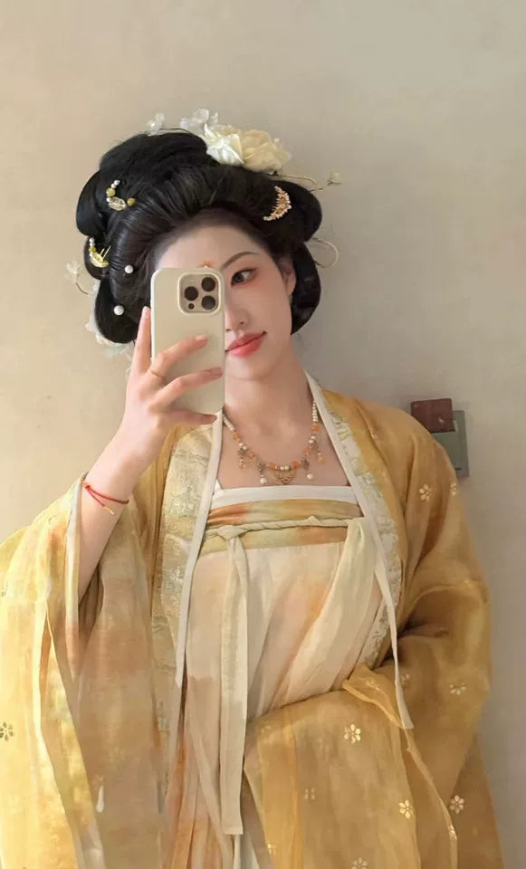 Person wearing a  yellow Golden Traditional Chinese Tang Dynasty Hanfu Dress Set with intricate hair styling, taking a mirror selfie.