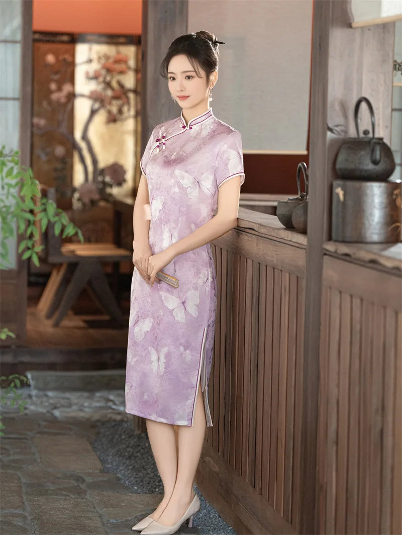 Woman in a traditional Lavender Butterfly Print Midi Qipao Dress outfit standing in a room with wooden furniture and plants.