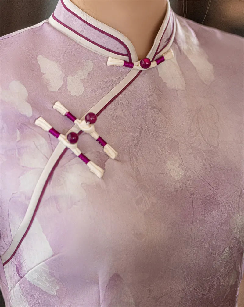 Traditional Chinese garment with floral patterns and decorative buttons on a mannequin.