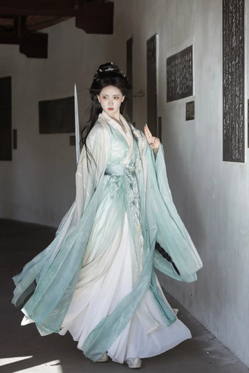 Person wearing traditional Chinese attire Mint Green Wei-Jin Dynasty Flowing Robe Hanfu Dress in a minimalistic indoor setting