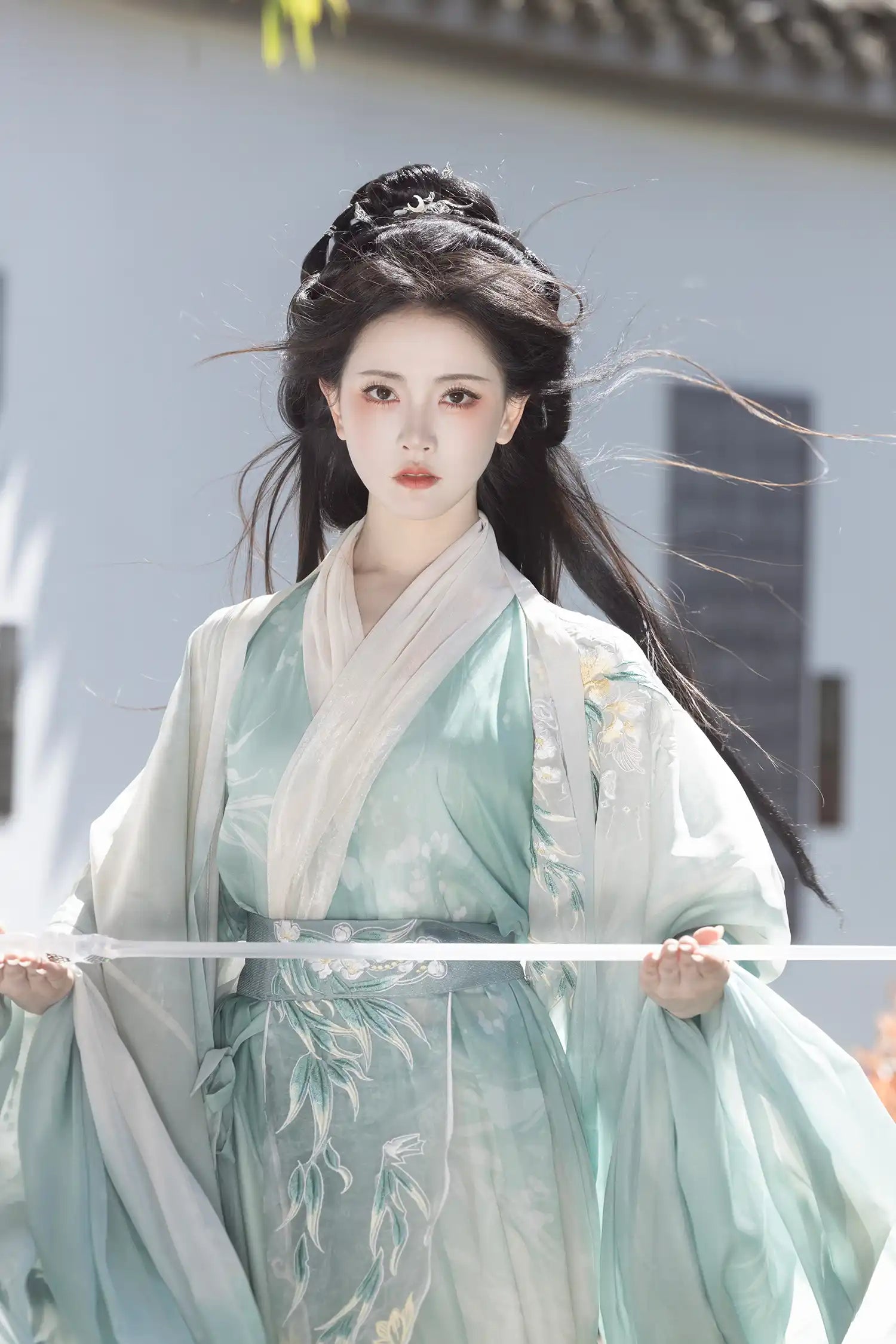 Person wearing traditional Chinese attire Mint Green Wei-Jin Dynasty Flowing Robe Hanfu Dress with a blurred background