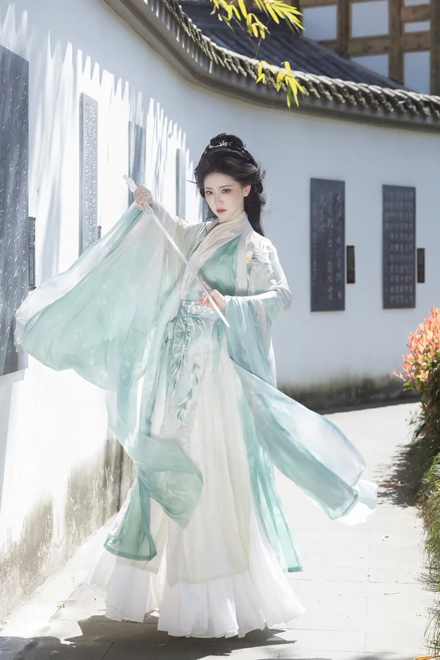 Woman in traditional Mint Green Wei-Jin Dynasty Flowing Robe Hanfu Dress  standing in a scenic outdoor setting.