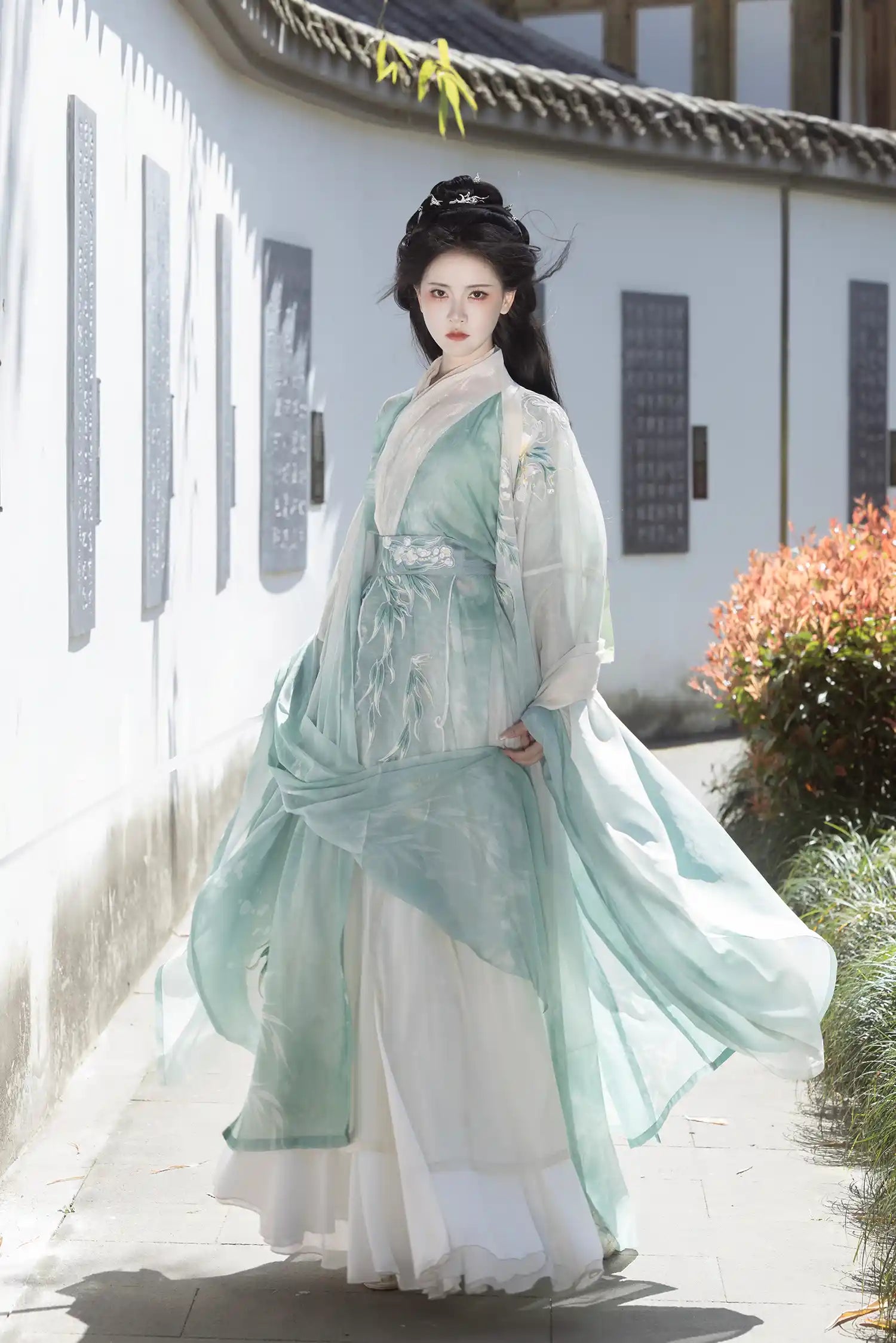 Woman in traditional light Mint Green Wei-Jin Dynasty Flowing Robe Hanfu Dress  standing in a garden setting.