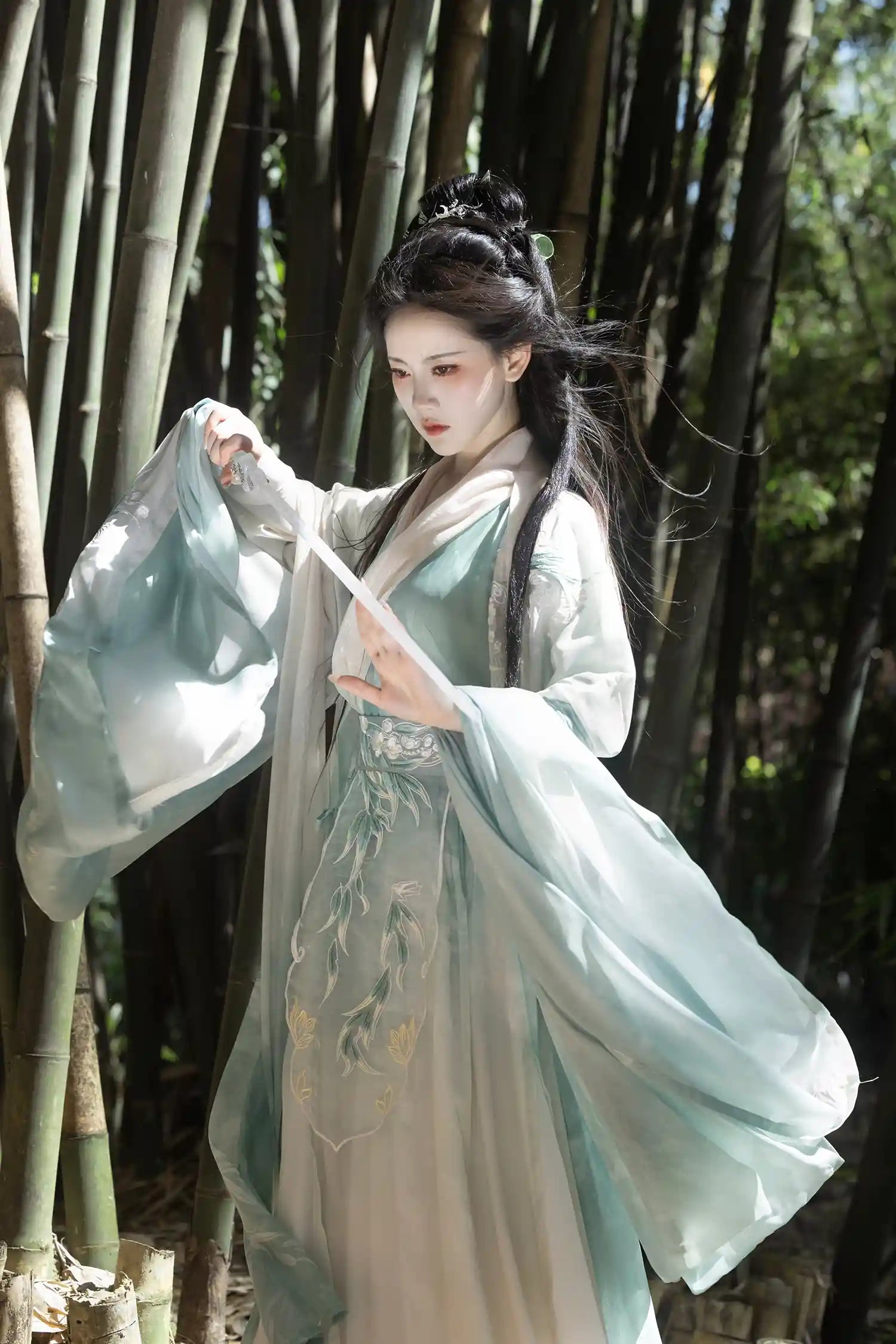 Person in traditional Mint Green Wei-Jin Dynasty Flowing Robe Hanfu Dress  garment standing among bamboo