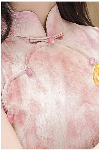 Close-up of a pink traditional outfit with floral patterns and buttons.