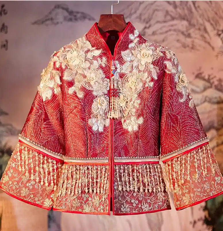 Decorative red garment with gold embroidery and tassels on a textured background