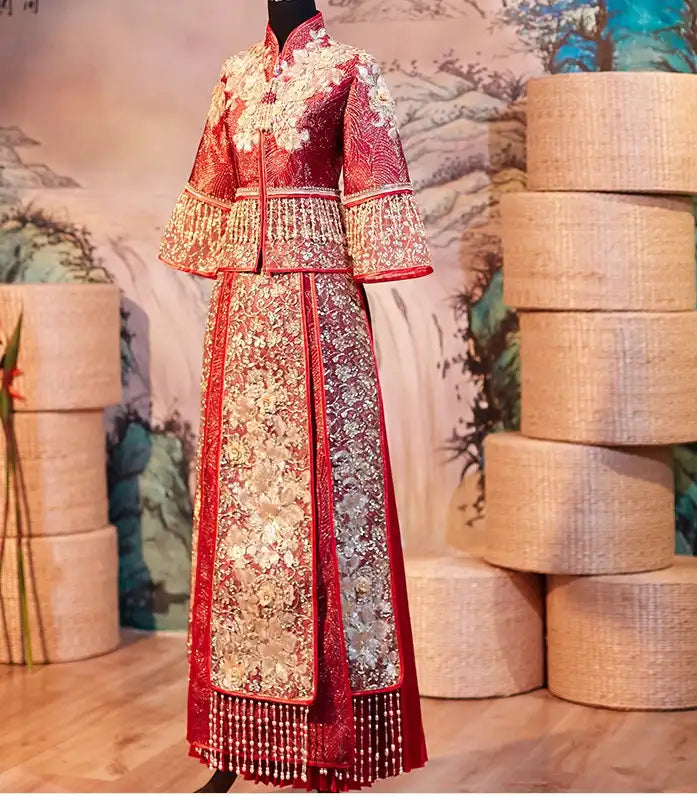 Red Glittering Qun Kwa Wedding Dress – Traditional Chinese Bridal Attire on a mannequin with a decorative background