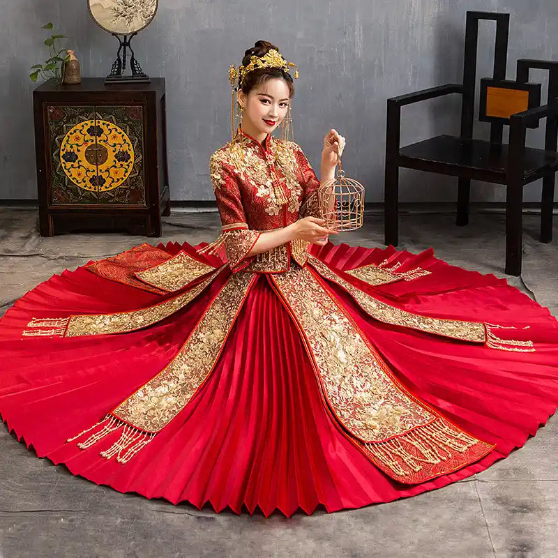Woman in Red Glittering Qun Kwa Wedding Dress – Traditional Chinese Bridal Attire holding a birdcage in a room with decorative elements.