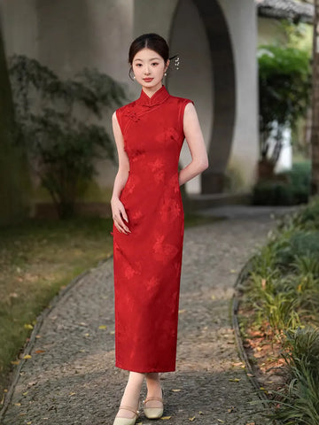 Woman in a Red Chinese Jacquard Sleeveless Modern Qipao Dress standing outdoors on a path with greenery.