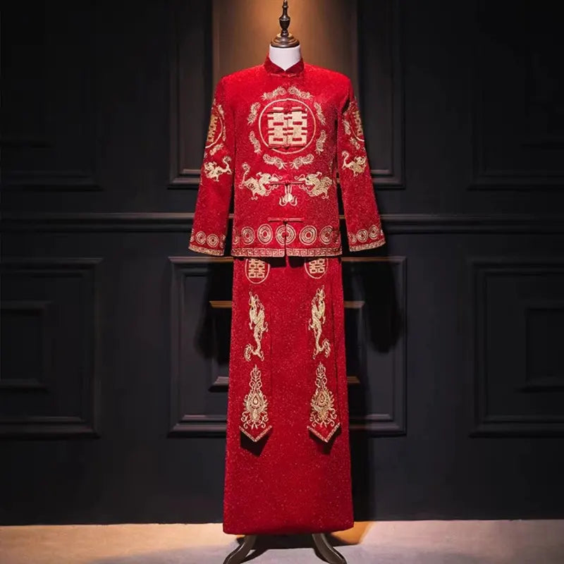 Traditional red Chinese wedding tang suit with gold embroidery on a mannequin against a dark background