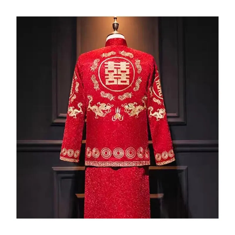 Red traditional chinese wedding outfit with gold embroidery on a mannequin against a dark background