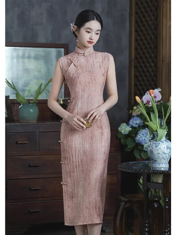 Woman in a Traditional Chinese Pastel Pink Sleeveless Qi pao Dress standing in an indoor setting with decor elements.