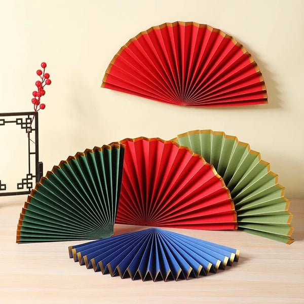 Set of colorful paper fans on a wooden surface with a neutral background