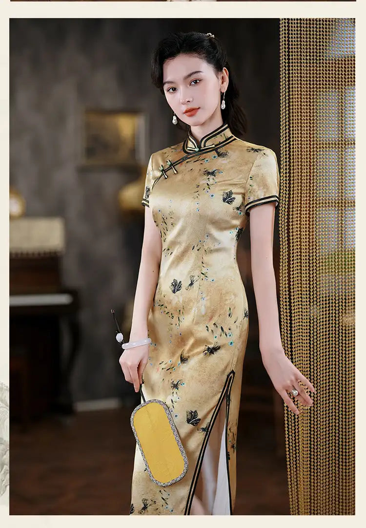 Woman in a traditional  Gold Mulberry Silk Qipao Dress with Black Floral Print , holding a yellow bag.