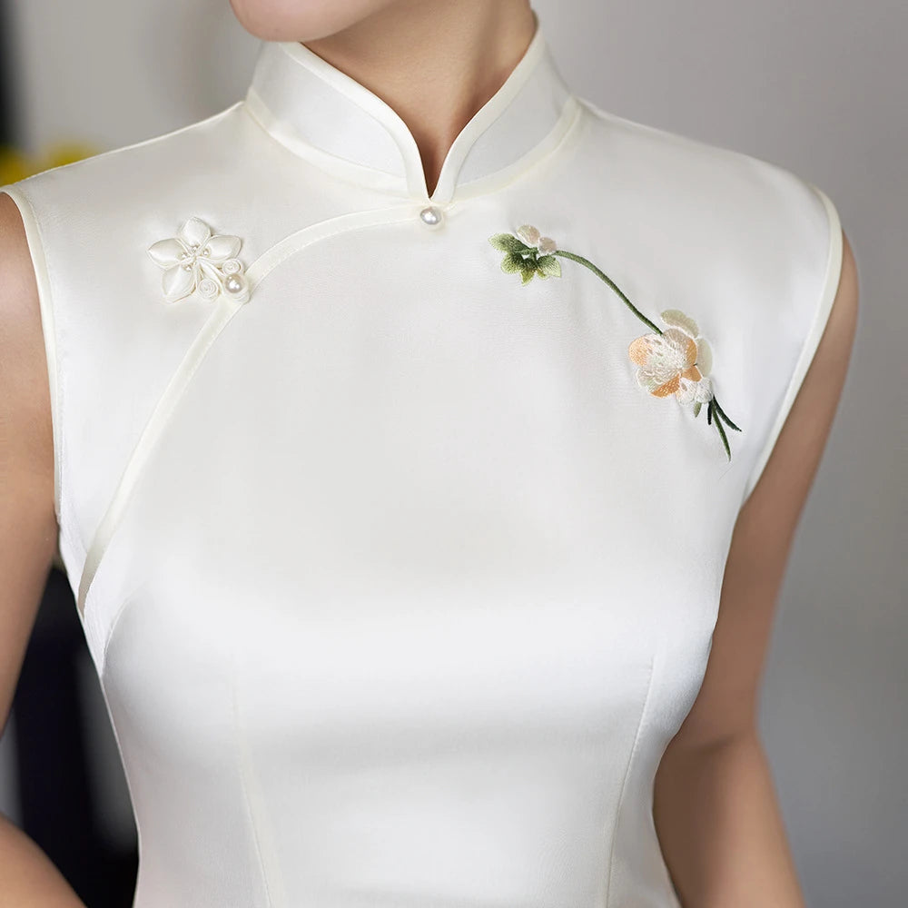Qipao long blanc sans manches orné de broderies d'orchidées