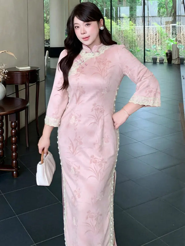 A woman modeling a light pink embroidered Plus size cheongsam dress with lace trim, holding a small white handbag in an indoor setting with dark tiled floors.