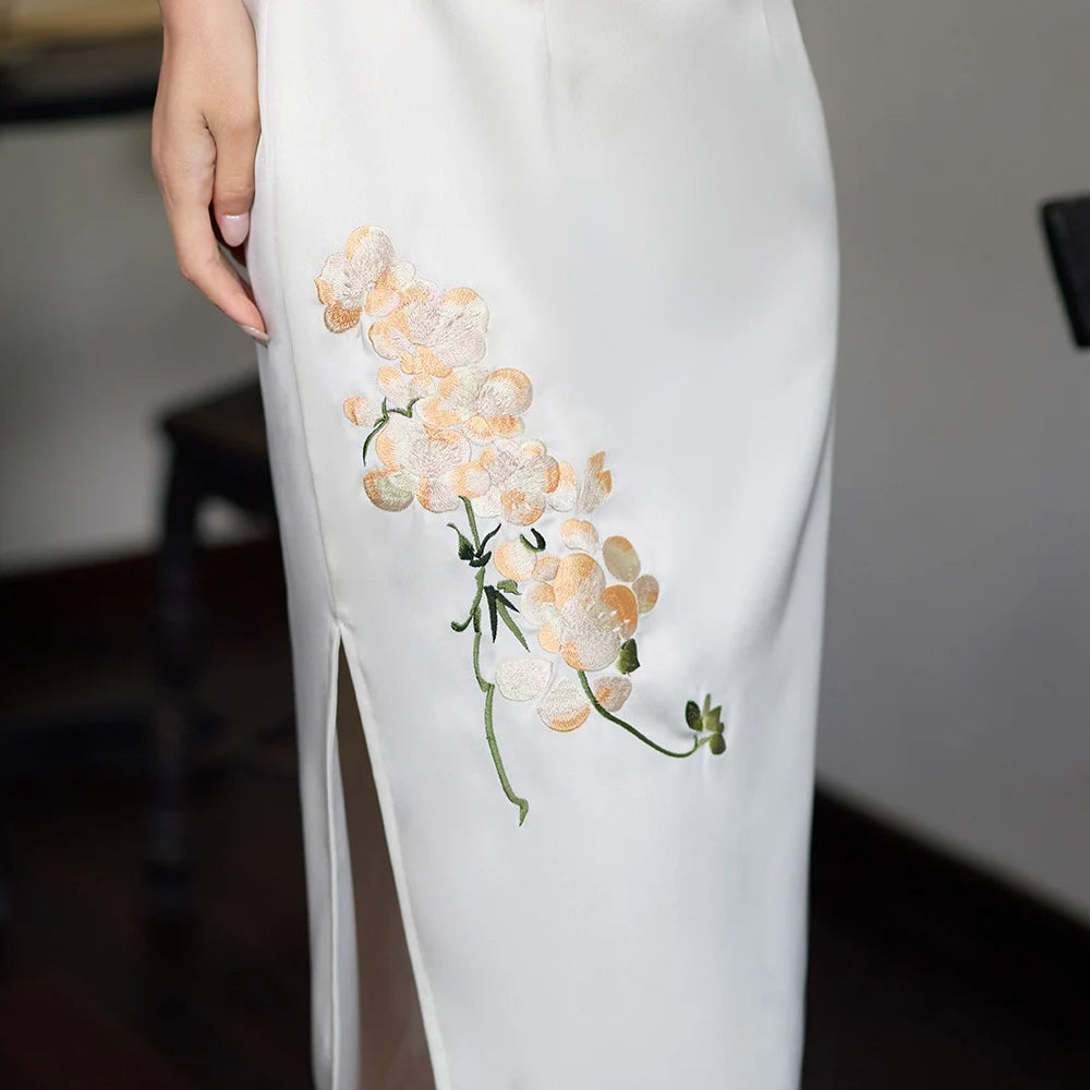 Qipao long blanc sans manches orné de broderies d'orchidées
