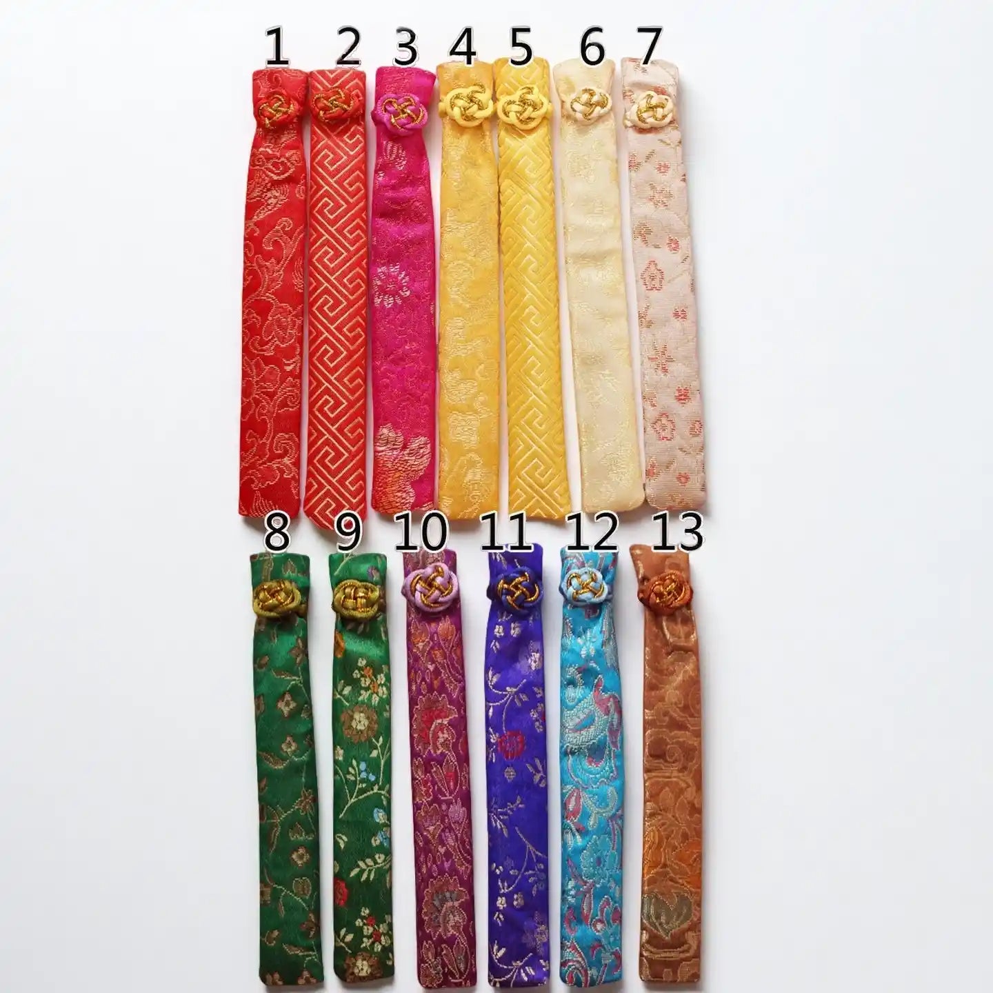 Set of 13 colorful fabric strips with patterns on a white background
