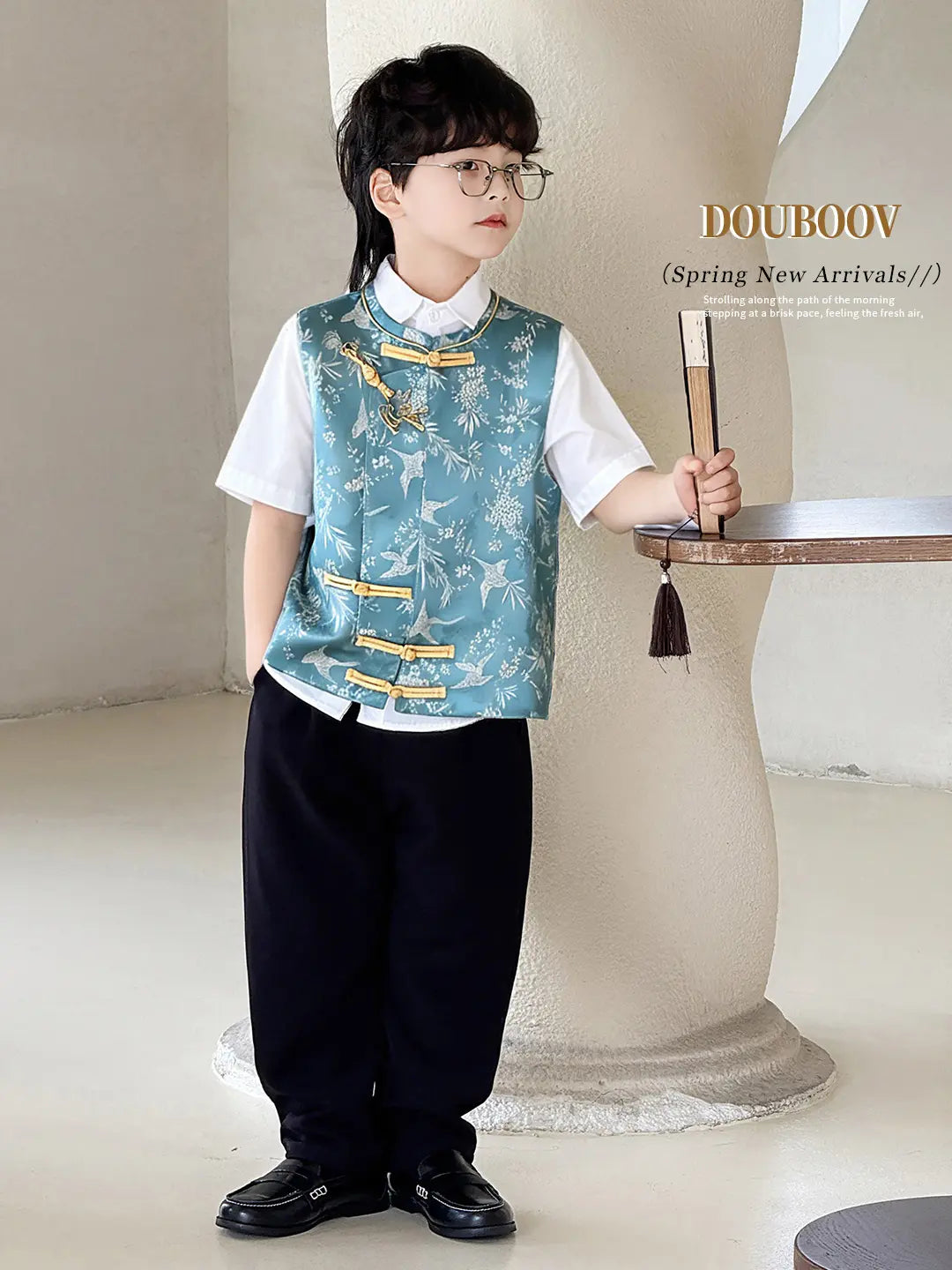 Child wearing a Boys' Traditional Chinese Style Blue Ves Outfit and glasses, standing indoors.