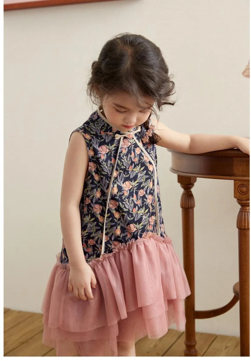 Young girl wearing a Modern Pink Floral Tulle Qipao Dressstanding near a wooden chair.