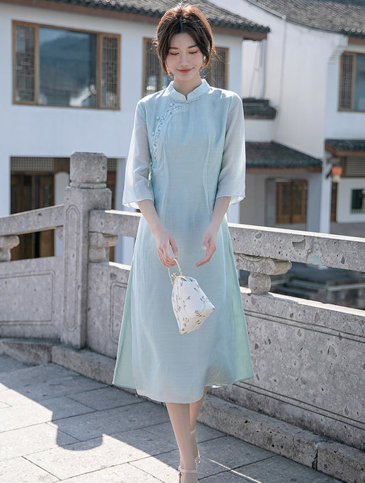 Model in light green loose qipao cheong dress looking down