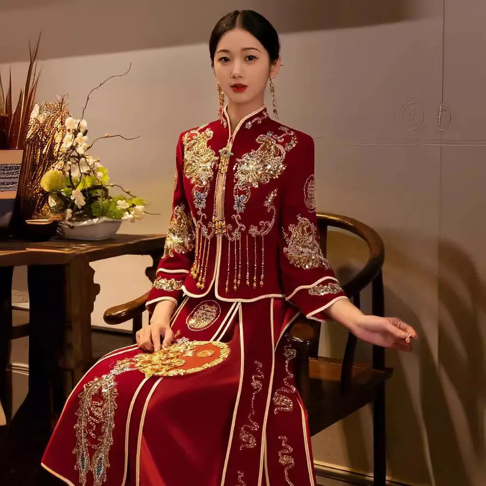 Woman in a Red Qun Kwa – Traditional Chinese Wedding gown sitting in a room with decor.