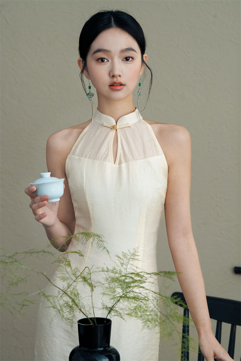 Model in White Halter Neck Qipao holding tea cup