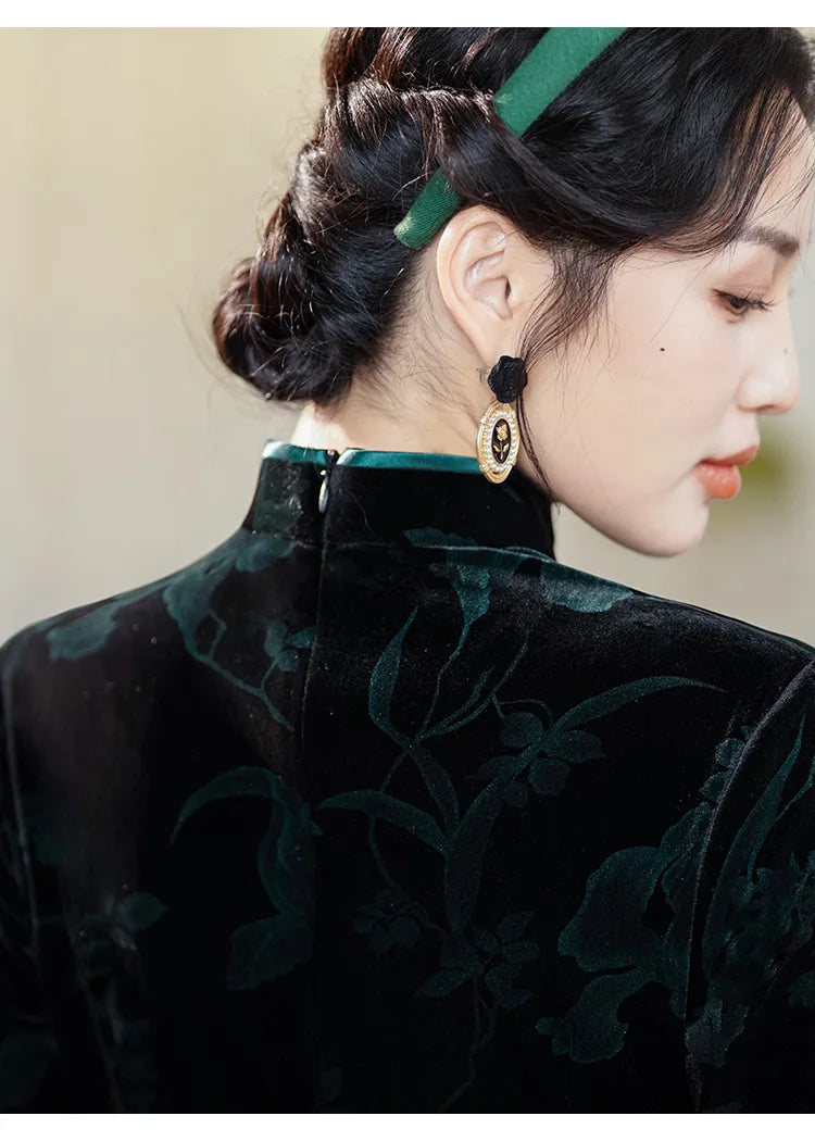 Woman wearing a black floral chinese dress with a green headband against a beige background