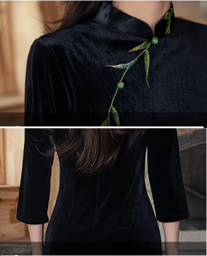 Black velvet dress with green embroidery details on a blurred background