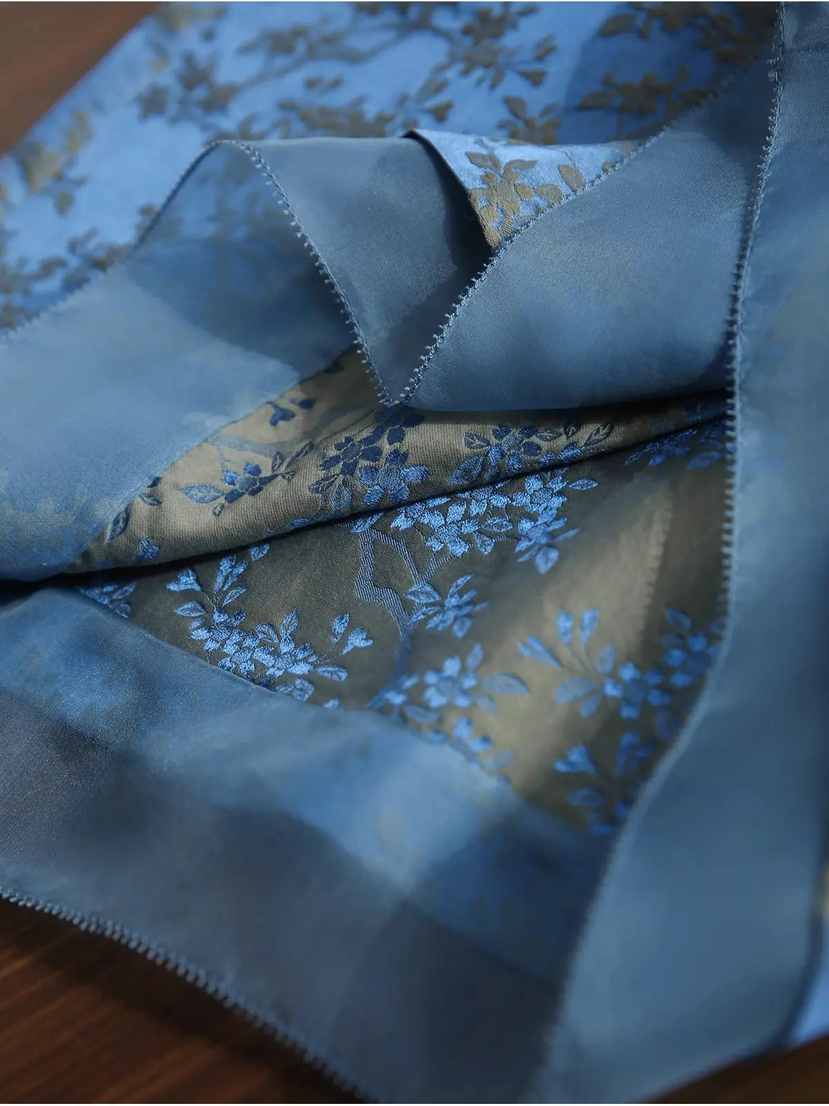 Blue Modern Silk-Cotton Blend Jacquard A-Line Loose Qipao  fabric with floral pattern on a wooden surface