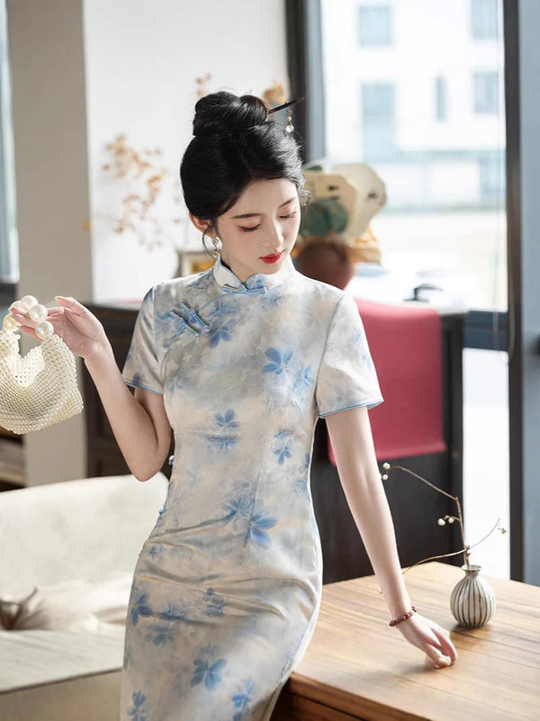 Woman in a Blue Watercolor Floral Long Qipao Cheongsam Dress standing in an indoor setting with decor elements.