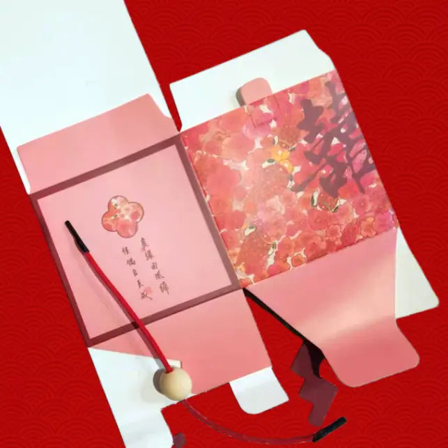 A pink and red Floral & Koi Fish Double Happiness Wedding Favor Boxes displayed on a textured red background.