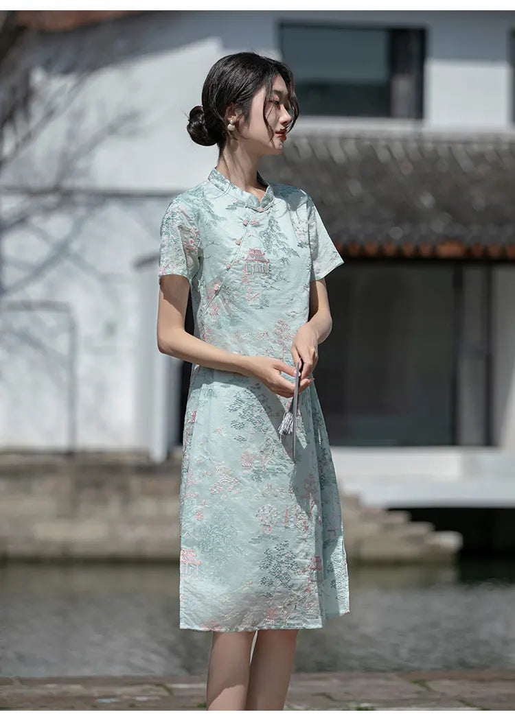 Woman in a light green floral a line loose qipao cheongsam dress standing outdoors with a blurred background