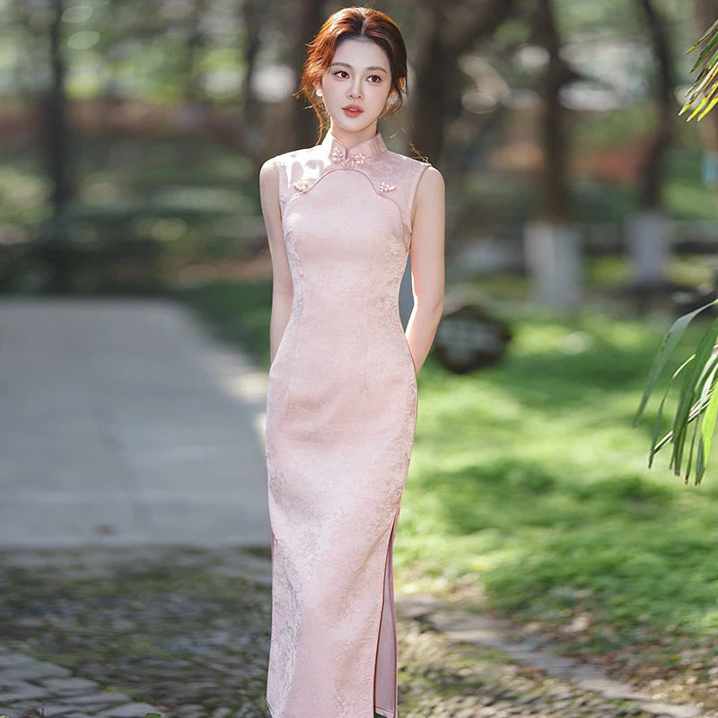 Woman in a long, Pastel Pink Sleeveless Modern Jacquard Qipao  dress standing outdoors with greenery in the background
