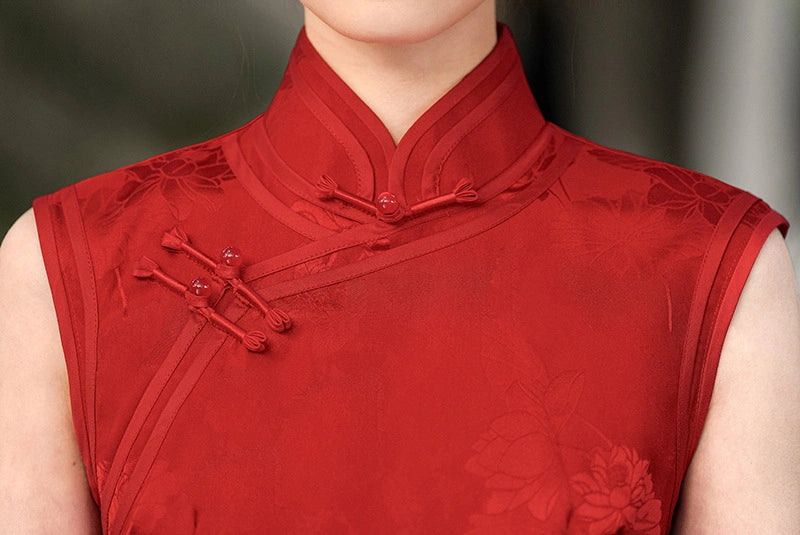 Red traditional qipao outfit with floral patterns on a blurred background