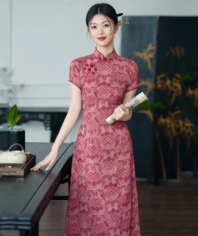 Woman in a red patterned dress holding a scroll in an indoor setting