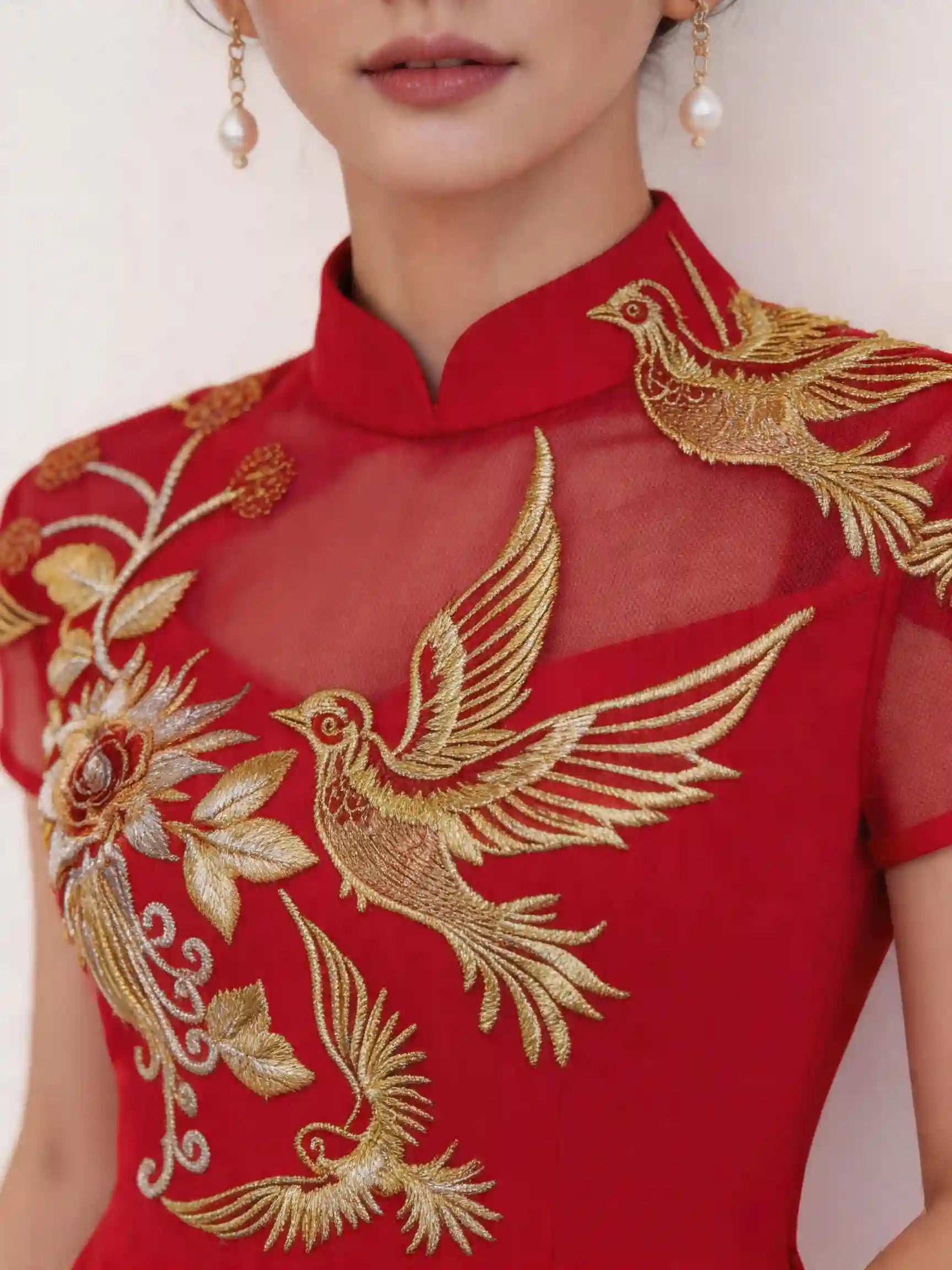 Red garment with gold embroidery featuring birds and floral designs.