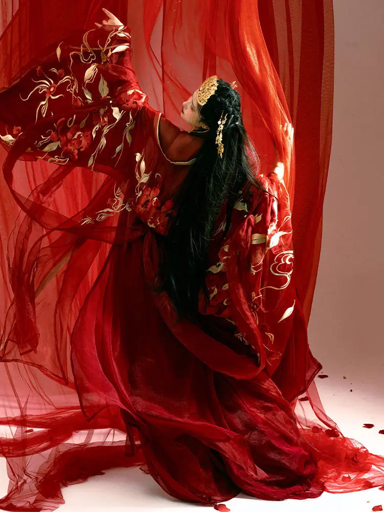 Person in a Traditonal Chinese Red Embroidered Tang Dynasty Hanfu Set  costume with long black hair against a red curtain.
