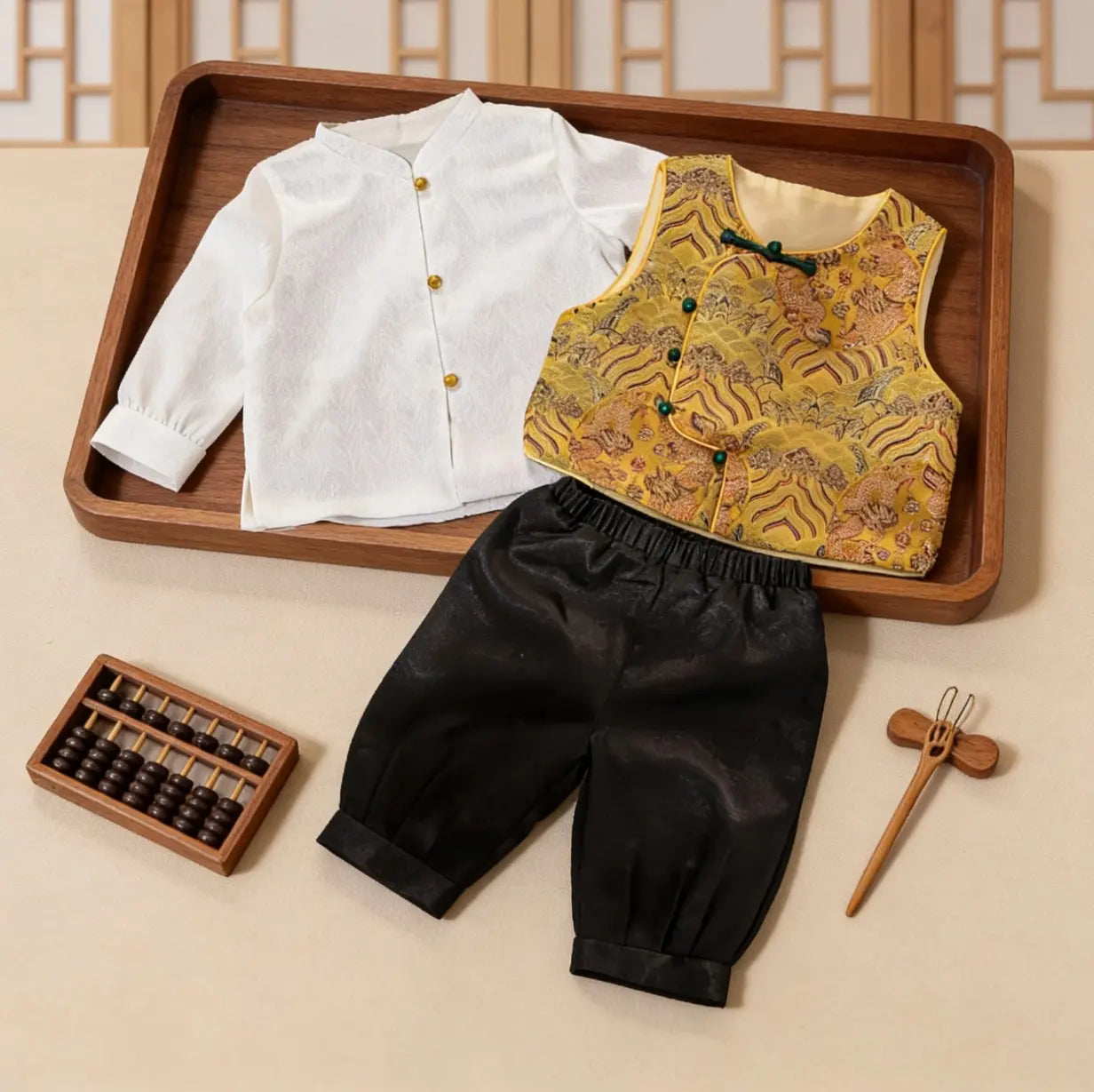 Traditional Chinese New Chinese Style Baby Boy Tang Suit Dragon Vest Set outfit with white shirt, yellow vest, and black pants on a wooden tray.