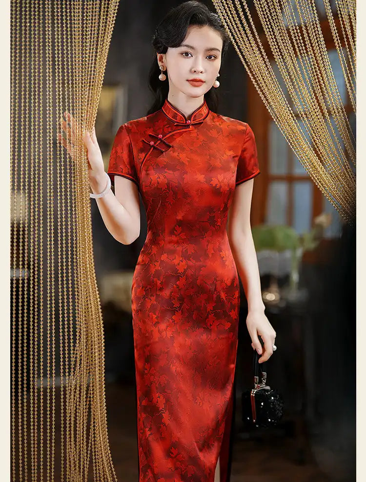 Woman in a red traditional Luxury Red Silk Qipao Dress with Maple Leaves Print standing in front of decorative curtains.