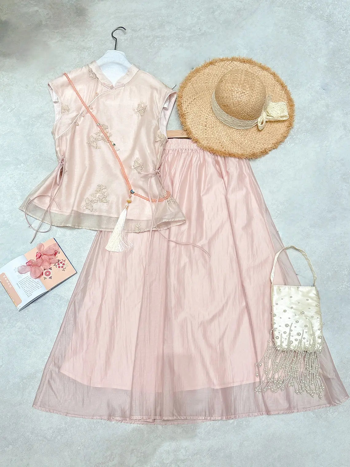 Pink floral New Chinese Style - Sleeveless Asymmetric Top & Maxi Skirt Set dress with a straw hat and handbag on a textured surface