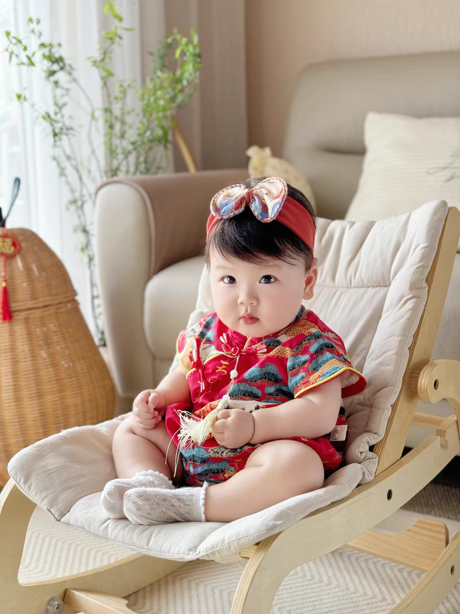 baby in red chinese baby romper sitting