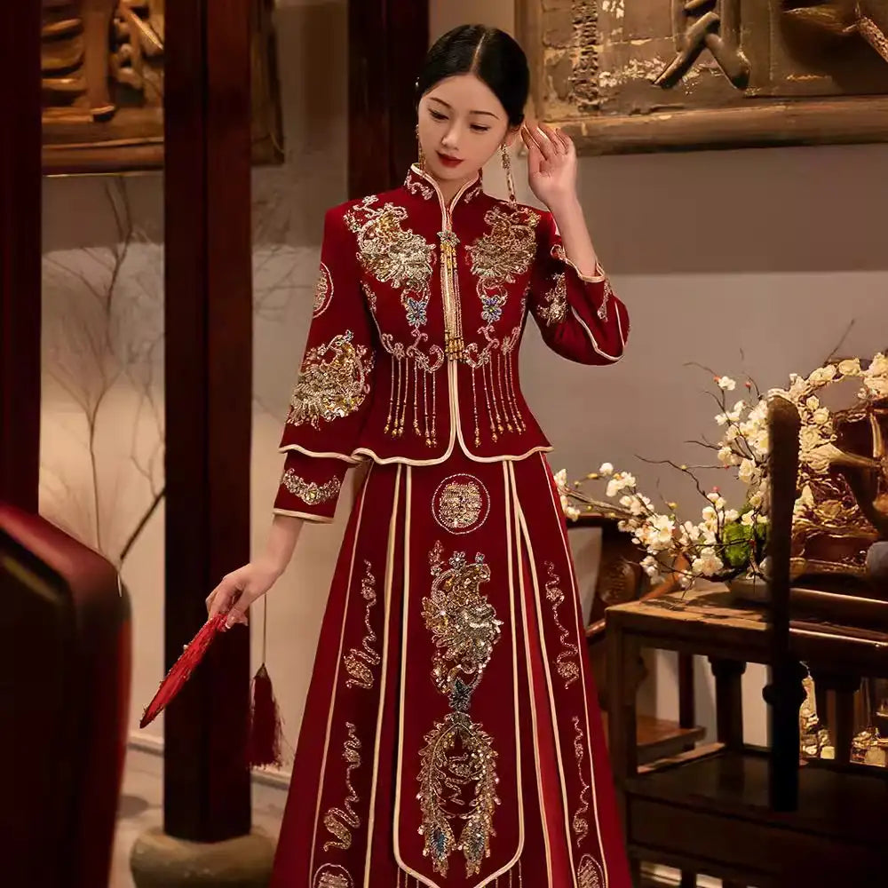 Woman in a Red Qun Kwa – Traditional Chinese Wedding Dress  standing in an elegant interior setting.